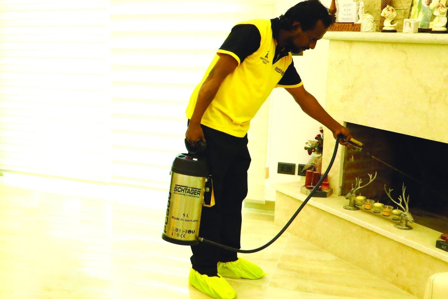 Schtager technician spraying for pests in a living room.