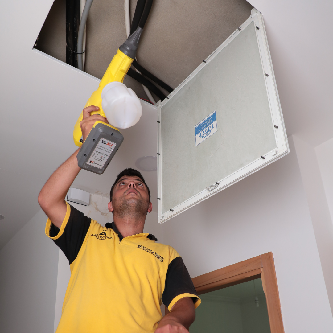 Technician applying odor removal treatment inside an air duct. 